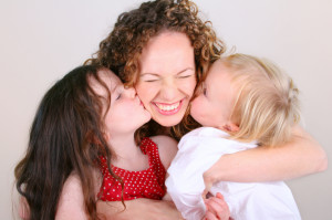children kissing mother iStock