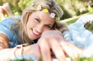Woman Lying In Park Wearing Flowers Around Hair