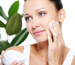 Woman applying moisturizer cream for her pretty face