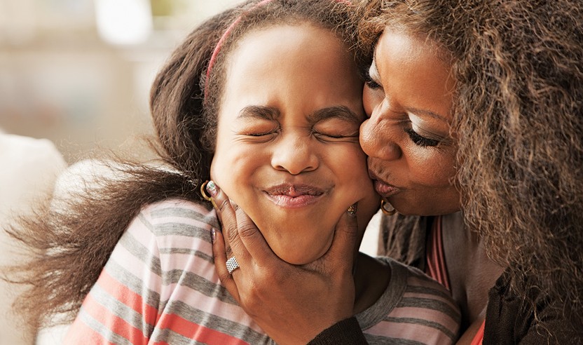 mom kissing daughter