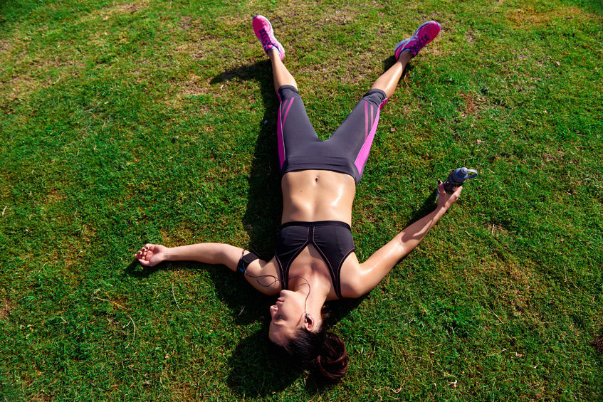 woman lying on grass, exhausted from running