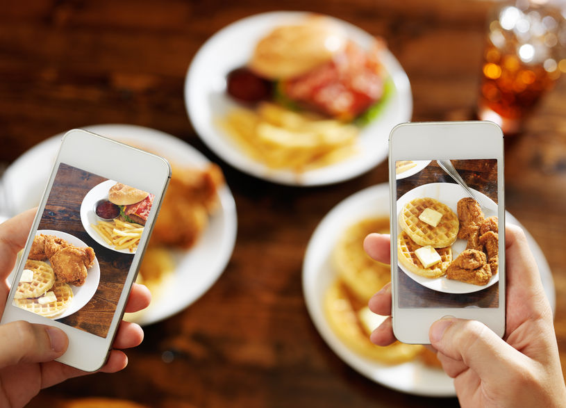 two smartphones taking images of breakfast plate