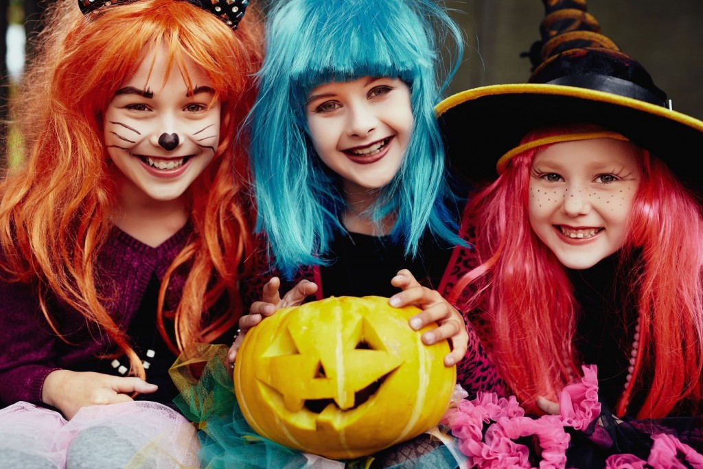 Group of girls in Halloween costumes looking at camera with smiles