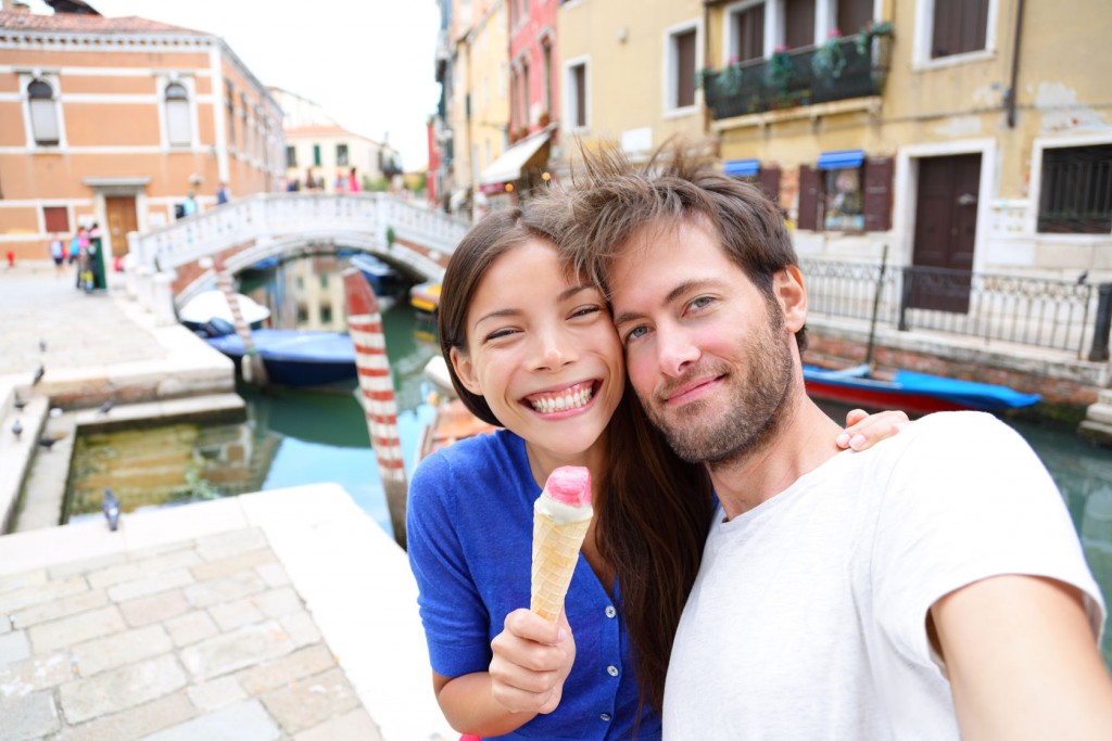Couple in Venice, eating Ice cream taking selfie self-portrait photo on vacation travel in Italy.