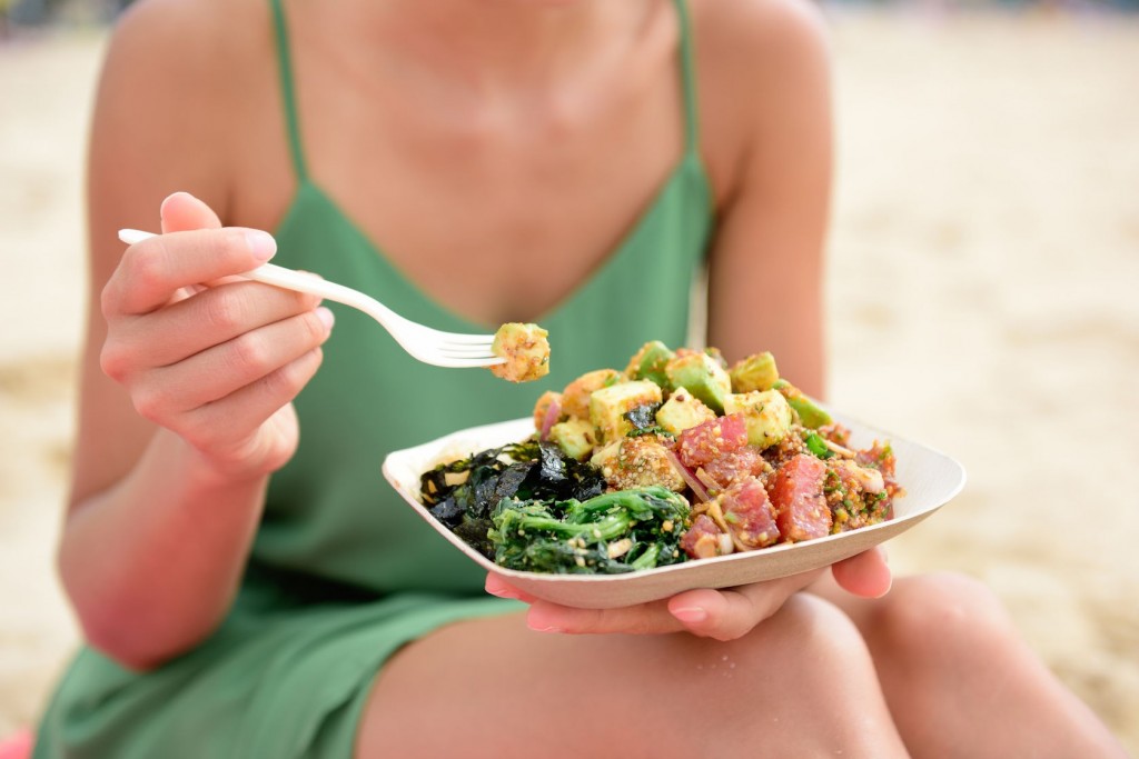 woman eating traditional poke bowl