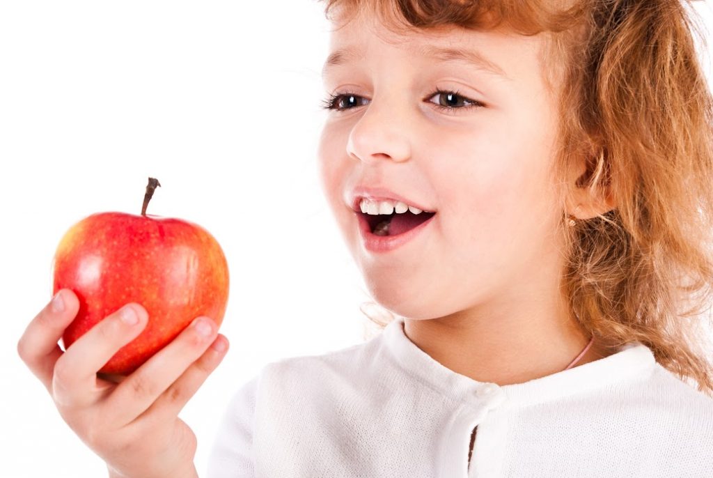 child eating apple against white background