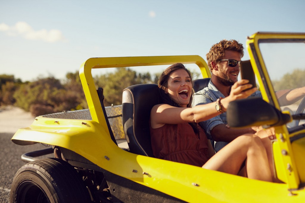 happy couple riding in beach buggy