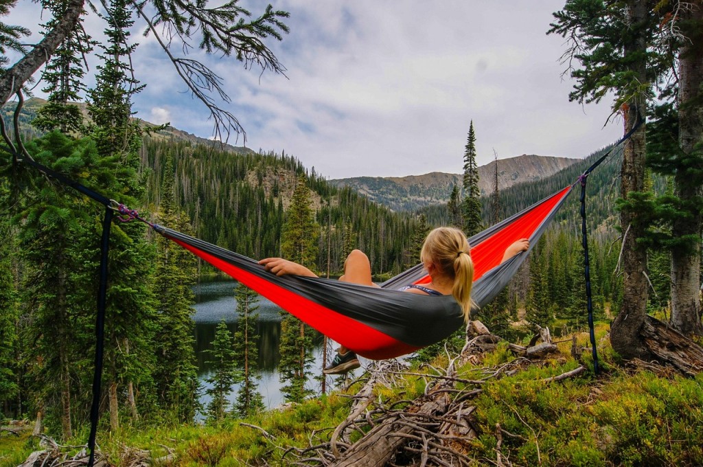 woman relaxing in hammock in forest